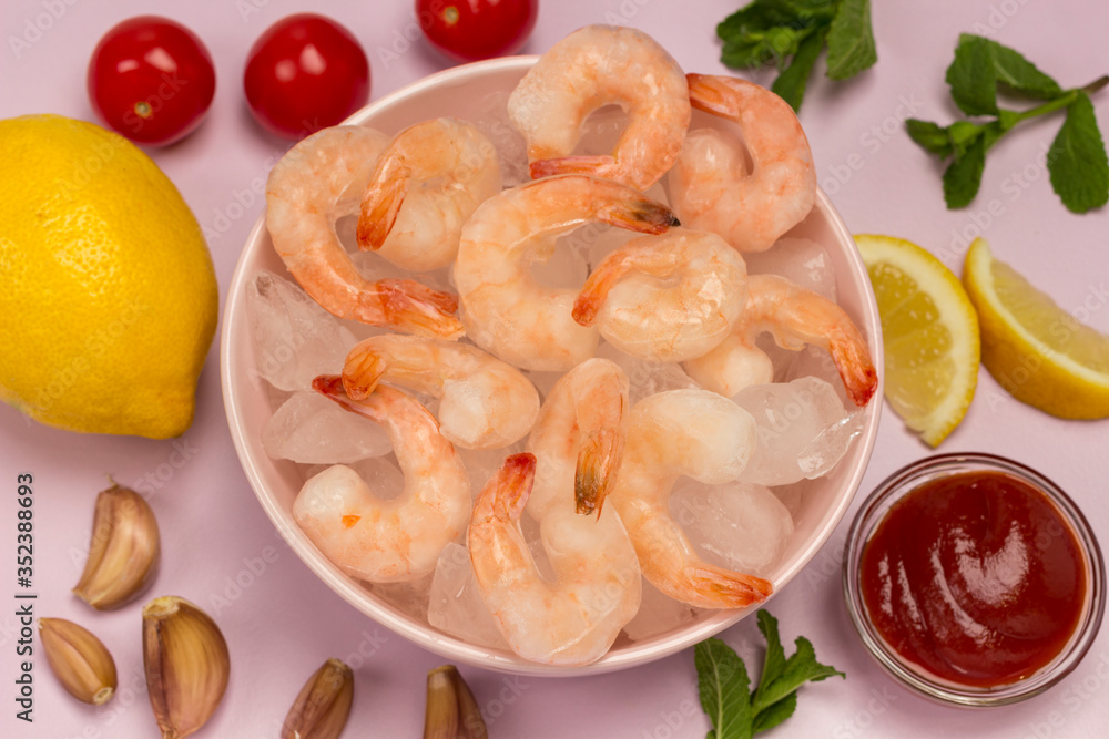 Tiger prawns with ice in a pink plate. Lemon, tomatoes, garlic and tomato sauce Tiger prawns with ice in a pink plate. Lemon, tomatoes, garlic and tomato sauce
