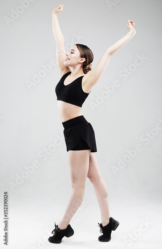 Fit and healthy woman. Happy fitness woman in sportwear jumping over white studio background. © Raisa Kanareva