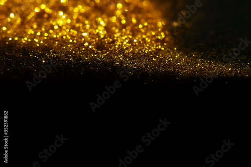 golden sparkles on black background. Christmas, Festive, Xmas backdrop. Copy space