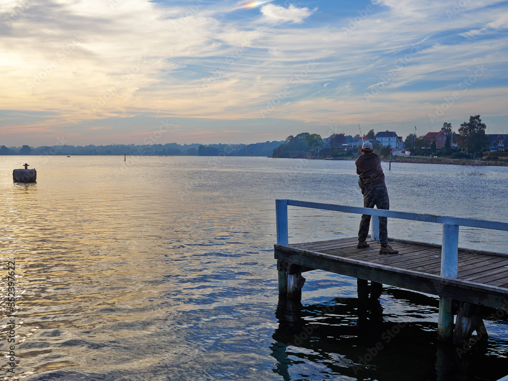 Fisherman in action on a wooden pier