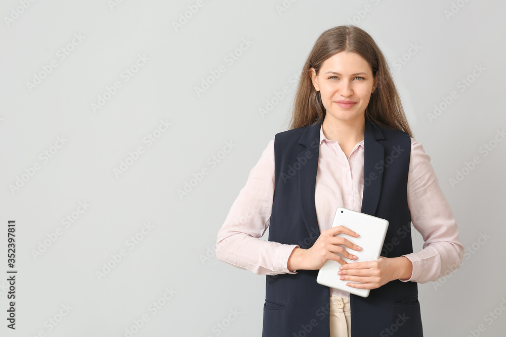 Beautiful young secretary with tablet computer on light background Beautiful young secretary with tablet computer on light background