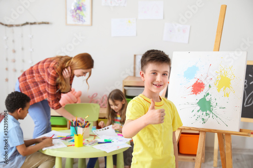 Cute boy painting at school