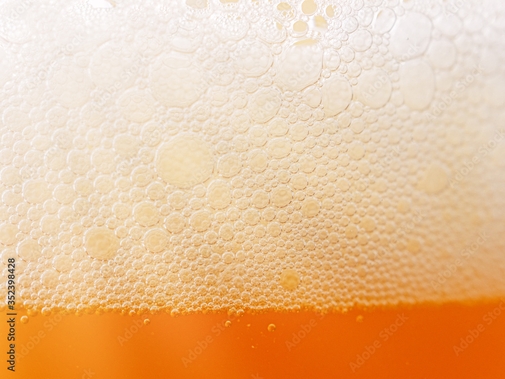 Rays of light pass through the foam on a beer in a glass goblet. Side view. Rays of light pass through the foam on a beer in a glass goblet. Side view.