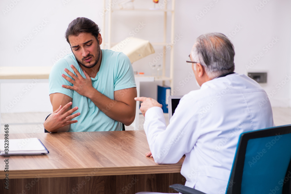 Injured young man visiting old doctor Injured young man visiting old doctor