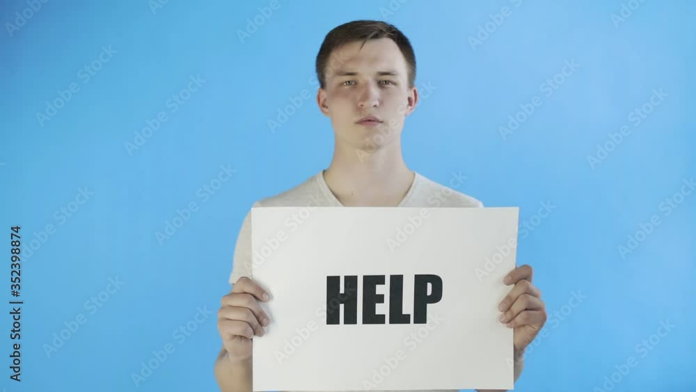 Young Man Activist With HELP Poster on blue background Young Man Activist With HELP Poster on blue background
