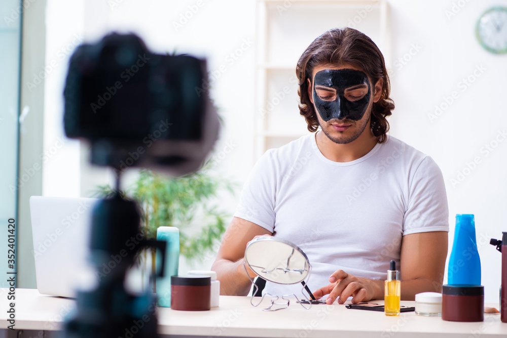 Young male cosmetician recording video for his blog Young male cosmetician recording video for his blog