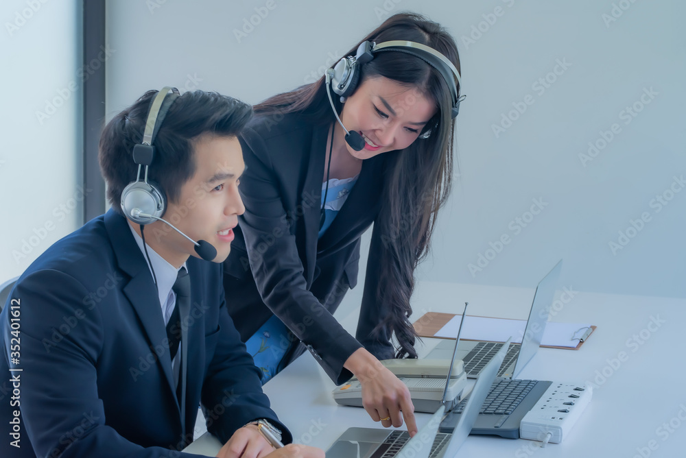 How can I help you? Beautiful call center employees in headphones are working at modern offices, focusing on woman. How can I help you? Beautiful call center employees in headphones are working at modern offices, focusing on woman.
