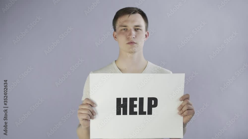 Young Man Activist With HELP Poster on grey background Young Man Activist With HELP Poster on grey background