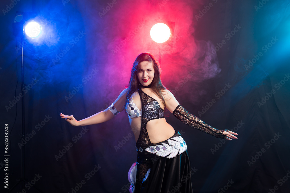 Girl dancing belly dance, fusion or tribal. A woman in a beautiful costume demonstrates charming and gentle movements in the dance.