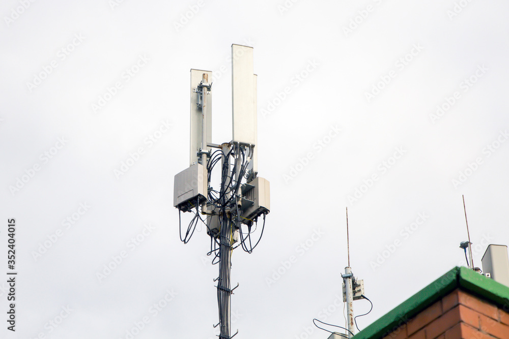 Telecommunication tower of 4G andcellular tower of 5G on the roof of a residential building. Radio tower with 5G network.