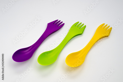 Tourist plastic fork spoon in different colors  photographed large on a white background.