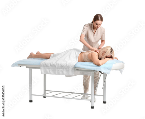 Massage therapist working with female patient on white background