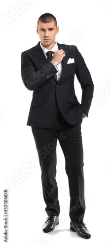 Handsome young man in elegant suit on white background