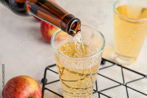 Obraz na płótnie Pouring of apple cider into glass on table