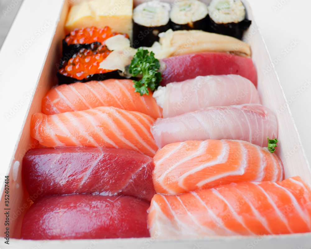 Various kinds of fresh sushi set in wooden box Various kinds of fresh sushi set in wooden box