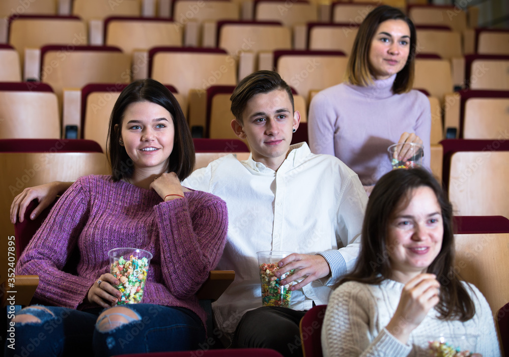 Spectators eating popcorn and watching a movie