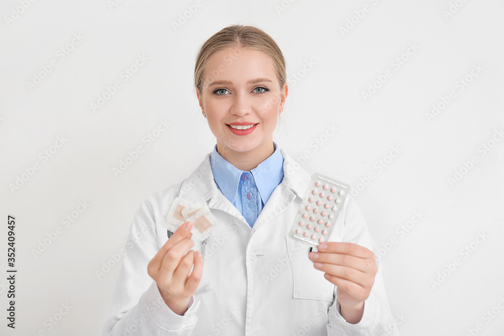Female gynecologist with different contraceptives on white background Female gynecologist with different contraceptives on white background
