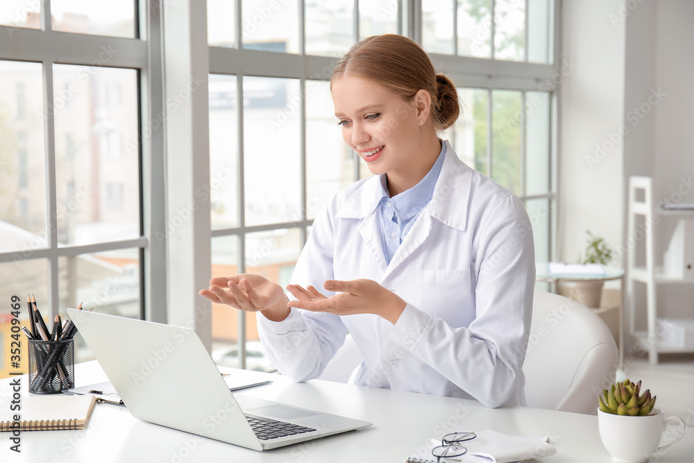 Female doctor giving a consultation online in clinic Female doctor giving a consultation online in clinic