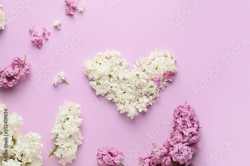 Composition with beautiful lilac flowers on color background