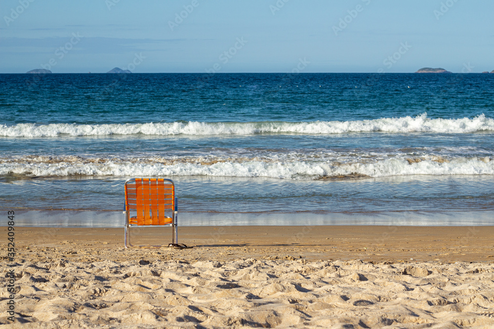 orange beach chair on beach facing the sea orange beach chair on beach facing the sea