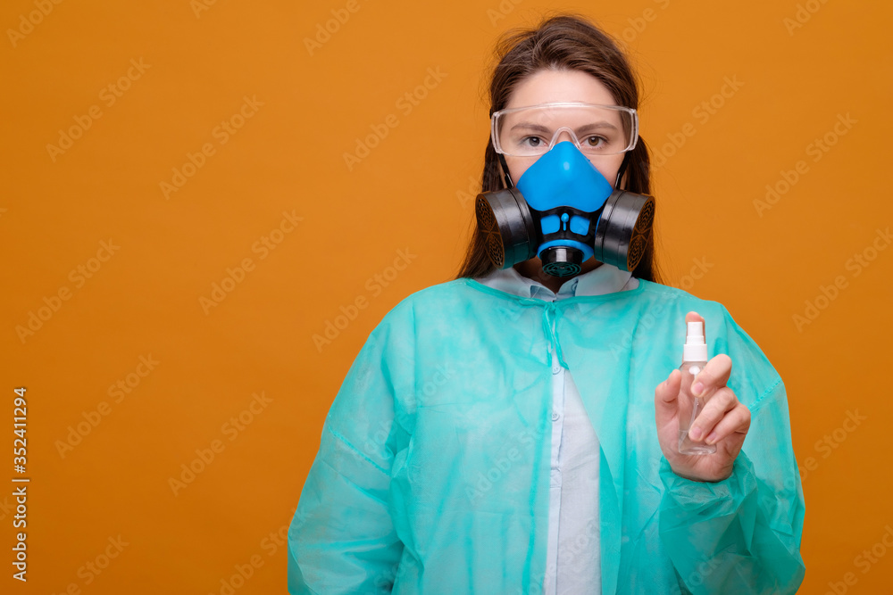 woman in protective medical equipment with antiseptic in hands medical mask on face on yellow background, coronavirus pandemic woman in protective medical equipment with antiseptic in hands medical mask on face on yellow background, coronavirus pandemic
