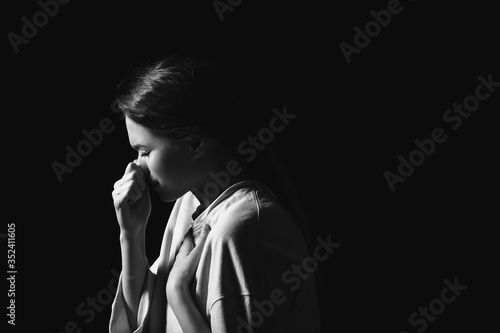 Coughing young woman on dark background. Concept of epidemic