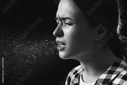 Coughing young woman on dar...