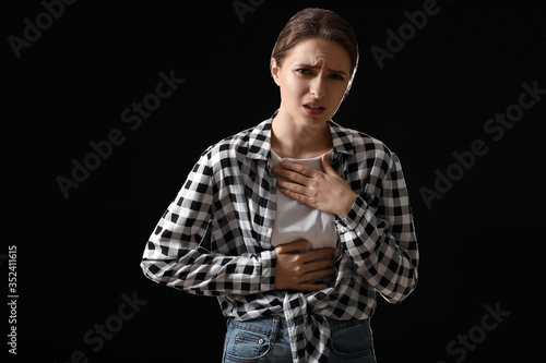 Coughing young woman on dar...