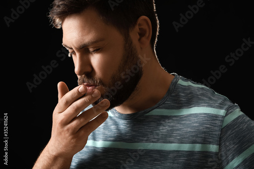 Coughing man on dark backgr...