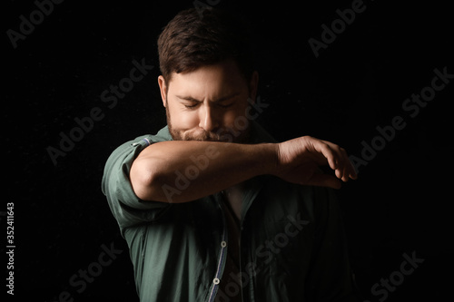 Coughing man on dark backgr...