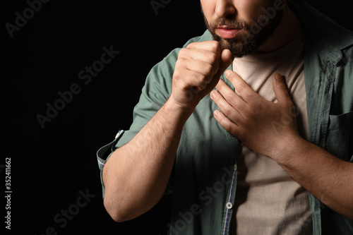 Coughing man on dark backgr...