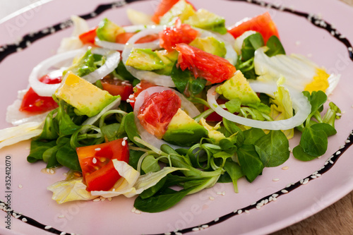 Salad of avocado, tomatoes, grapefruit and corn salad at plate