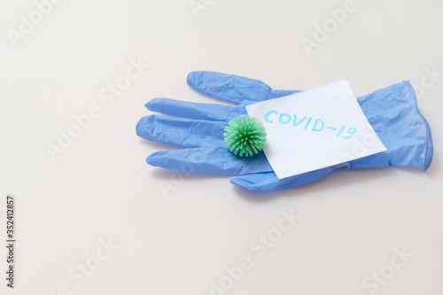 virus bacteria on rubber glove note with words covid-19 top view