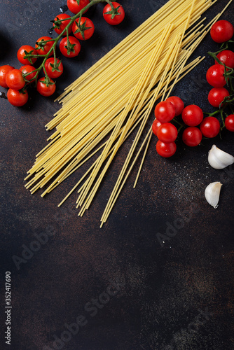 spaghetti, tomato and garlic on the black table