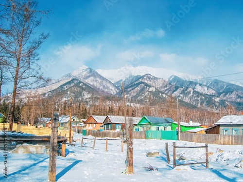 Village at the foot of the mountains in winter, winter background