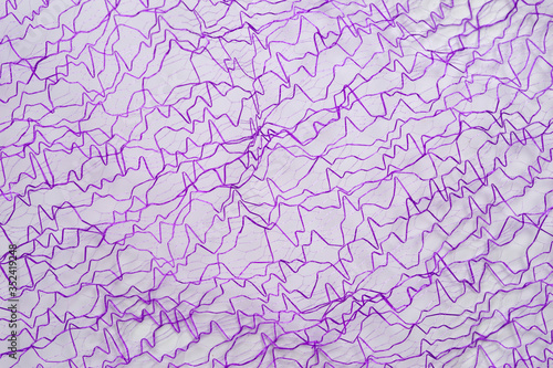 A purple guipure with satin thread, photographed in close-up. Background for the texture of outerwear and fashion.