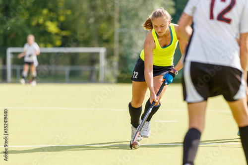 Field hockey female player lead the ball in attack