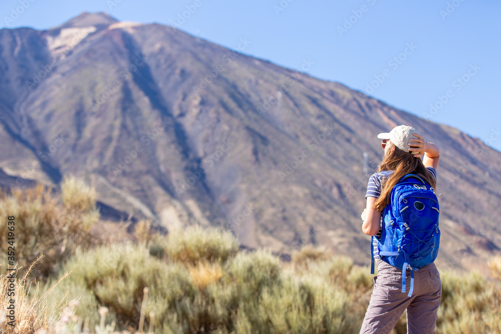 Young woman with backpack standing near Teide