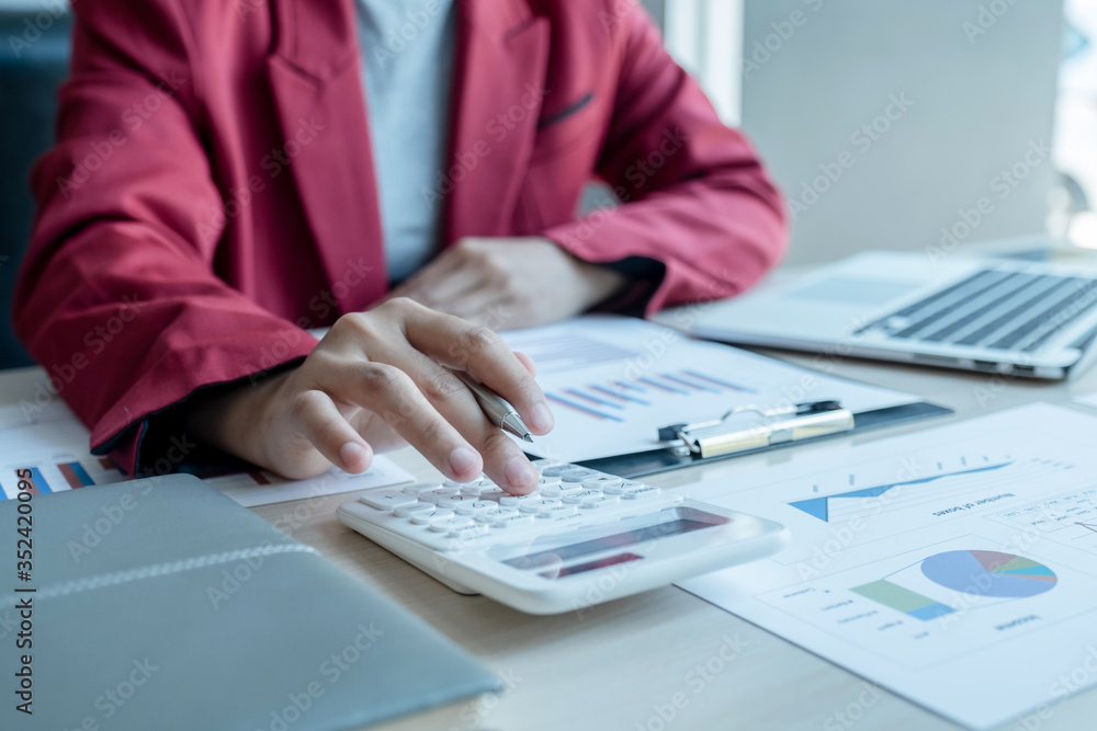 business man is sitting at a desk and calculating financial graph that show results business man is sitting at a desk and calculating financial graph that show results