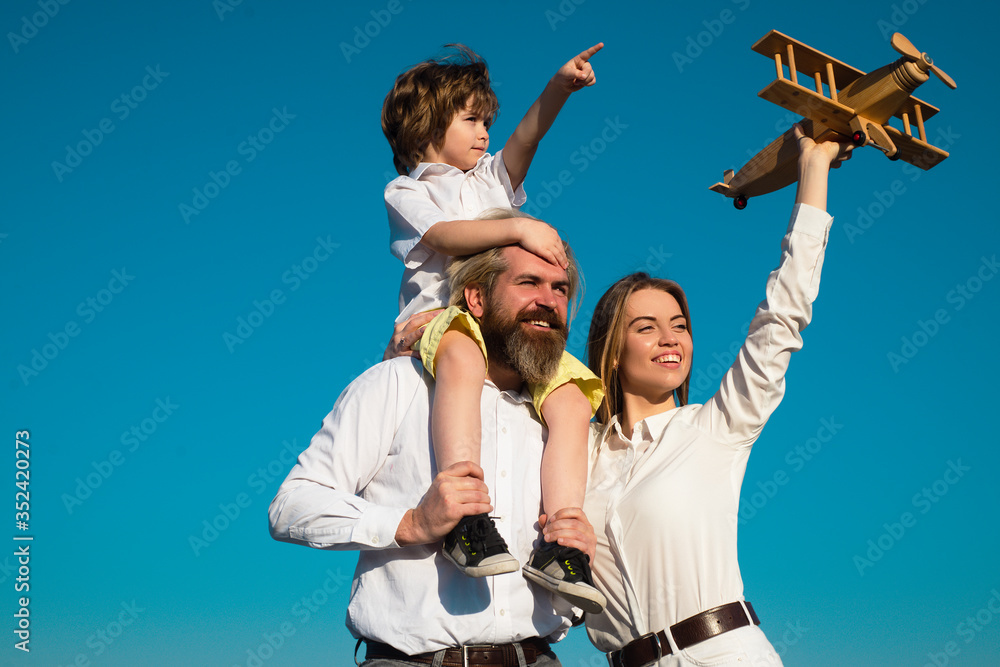 Family mother father and son dream about travel. Summer holiday and vacation concept. Son hugging parents on nature. Family traveling with child. Family mother father and son dream about travel. Summer holiday and vacation concept. Son hugging parents on nature. Family traveling with child.