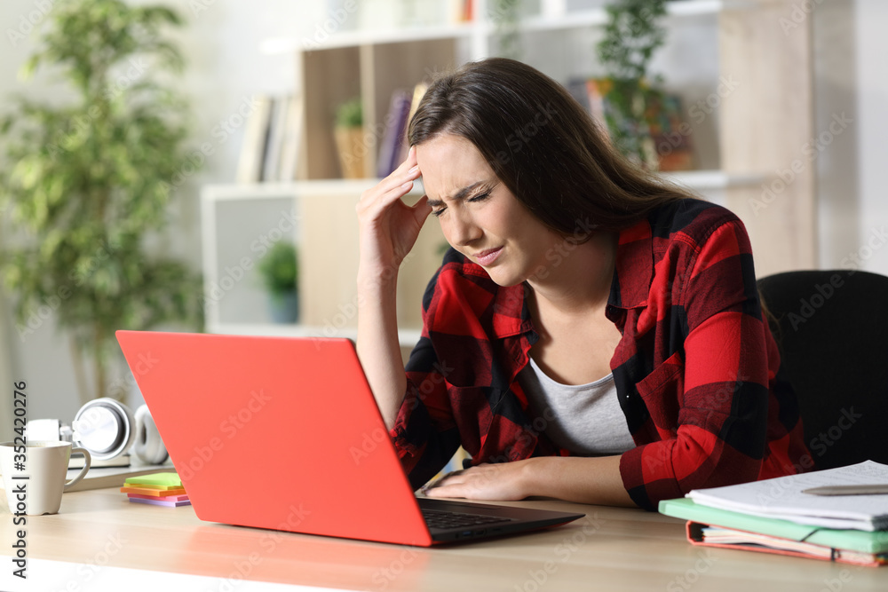 Student with laptop suffering headache at home Student with laptop suffering headache at home