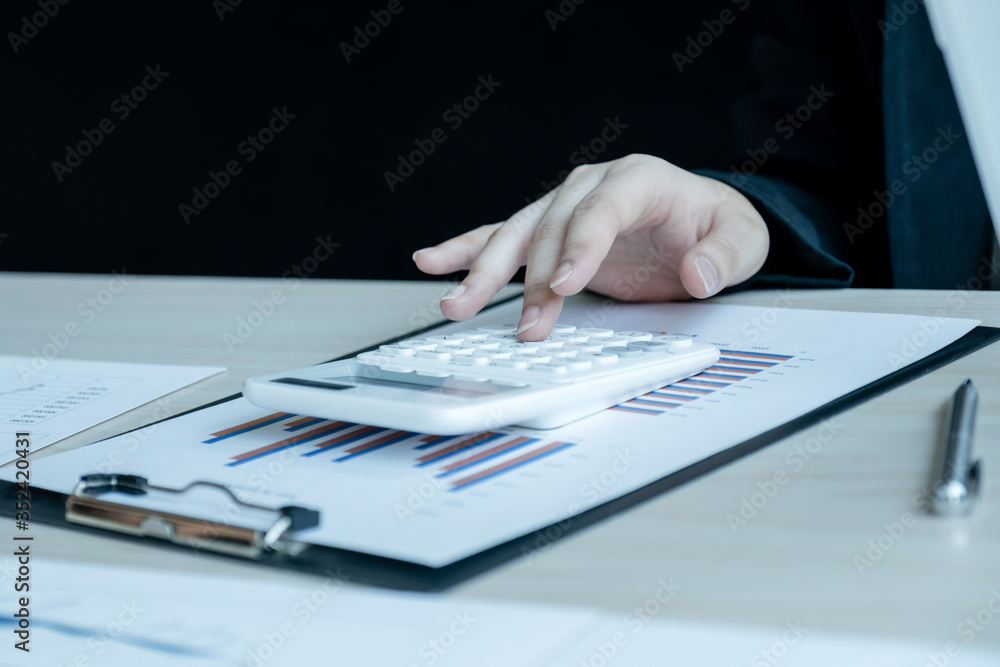 business man is sitting at a desk and calculating financial graph that show results