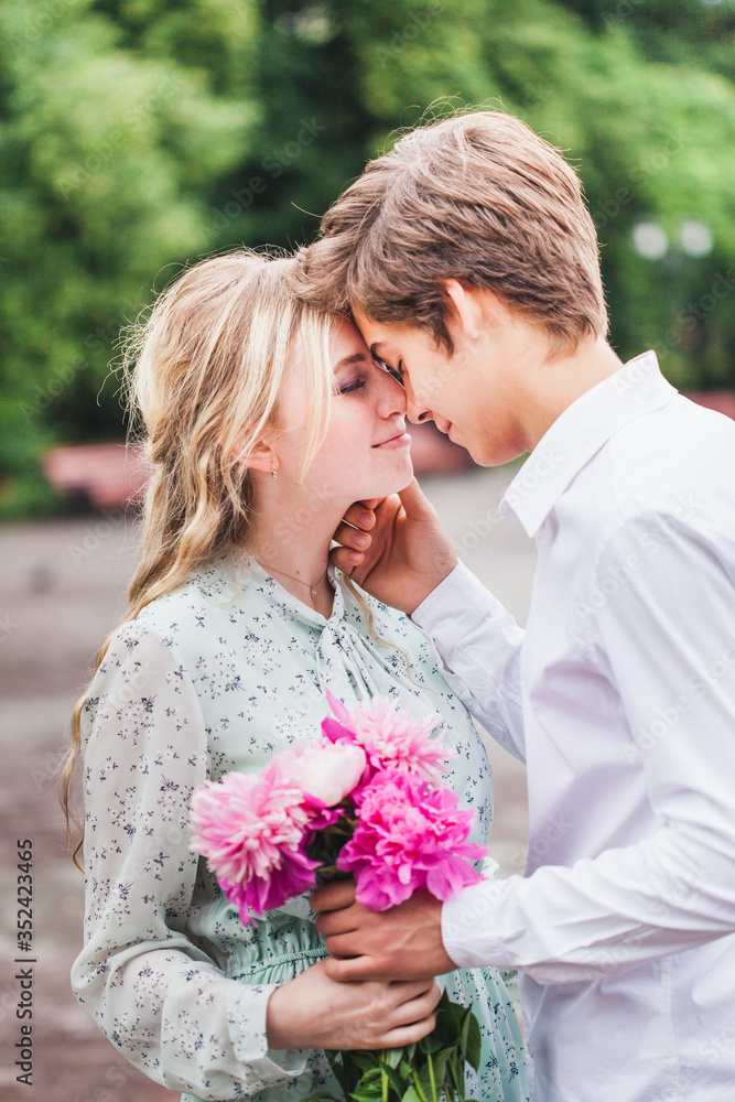 Naklejka premium A man gives his beloved, girl flowers, peonies, Declaration of love, proposal, marriage, meeting, date, kisses, summer, walk, bouquet