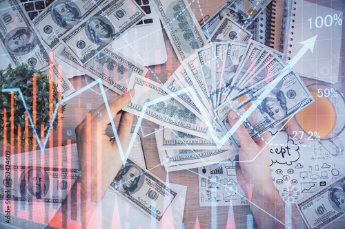 Multi exposure of financial graph drawing hologram and USA dollars bills and man hands. Analysis concept. © peshkova