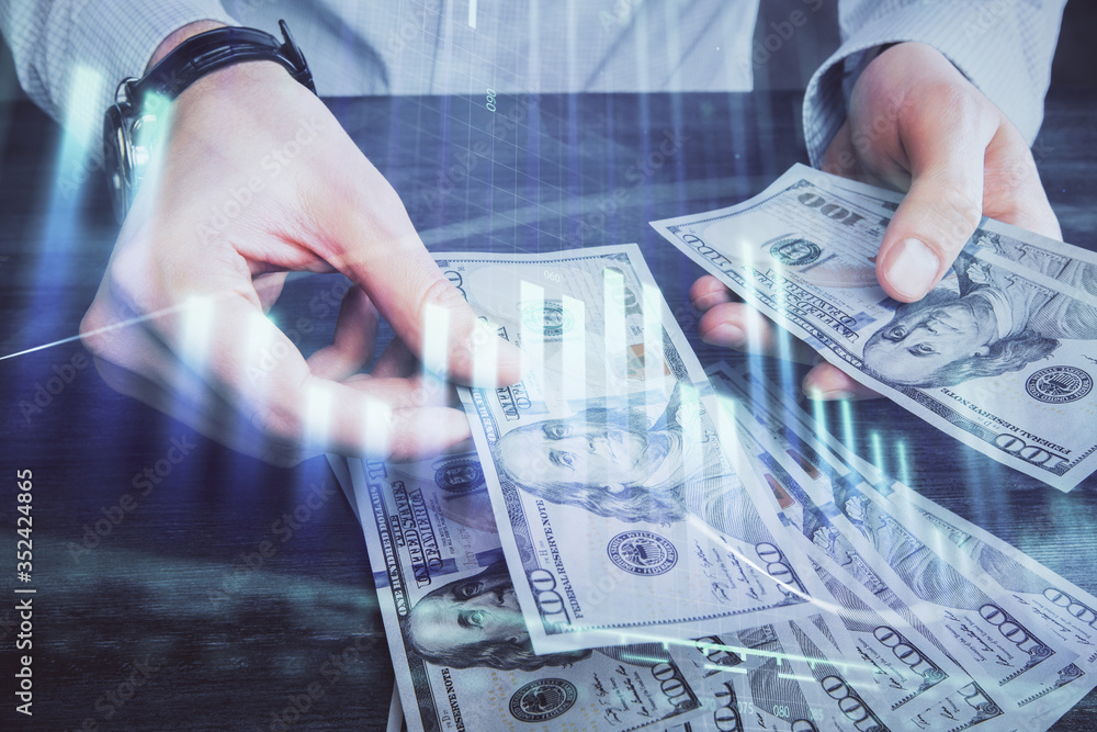 Multi exposure of financial graph drawing hologram and USA dollars bills and man hands. Analysis concept. Multi exposure of financial graph drawing hologram and USA dollars bills and man hands. Analysis concept.