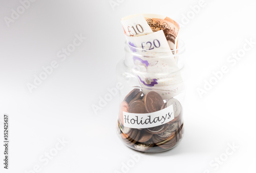 Holiday money with pennies in jar and currency on top of jar