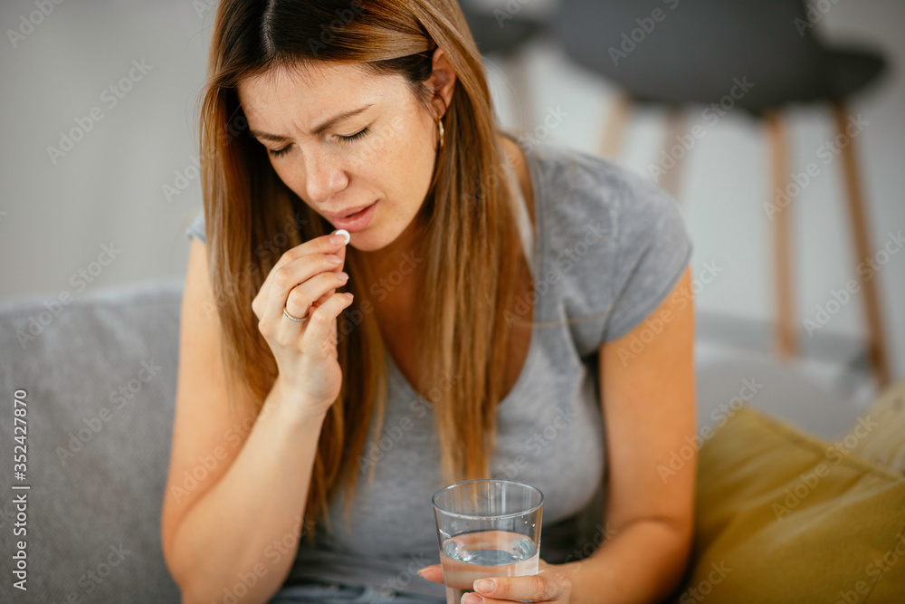 Woman having headache at home. Girl taking medicine pill for a cold. Woman having headache at home. Girl taking medicine pill for a cold.