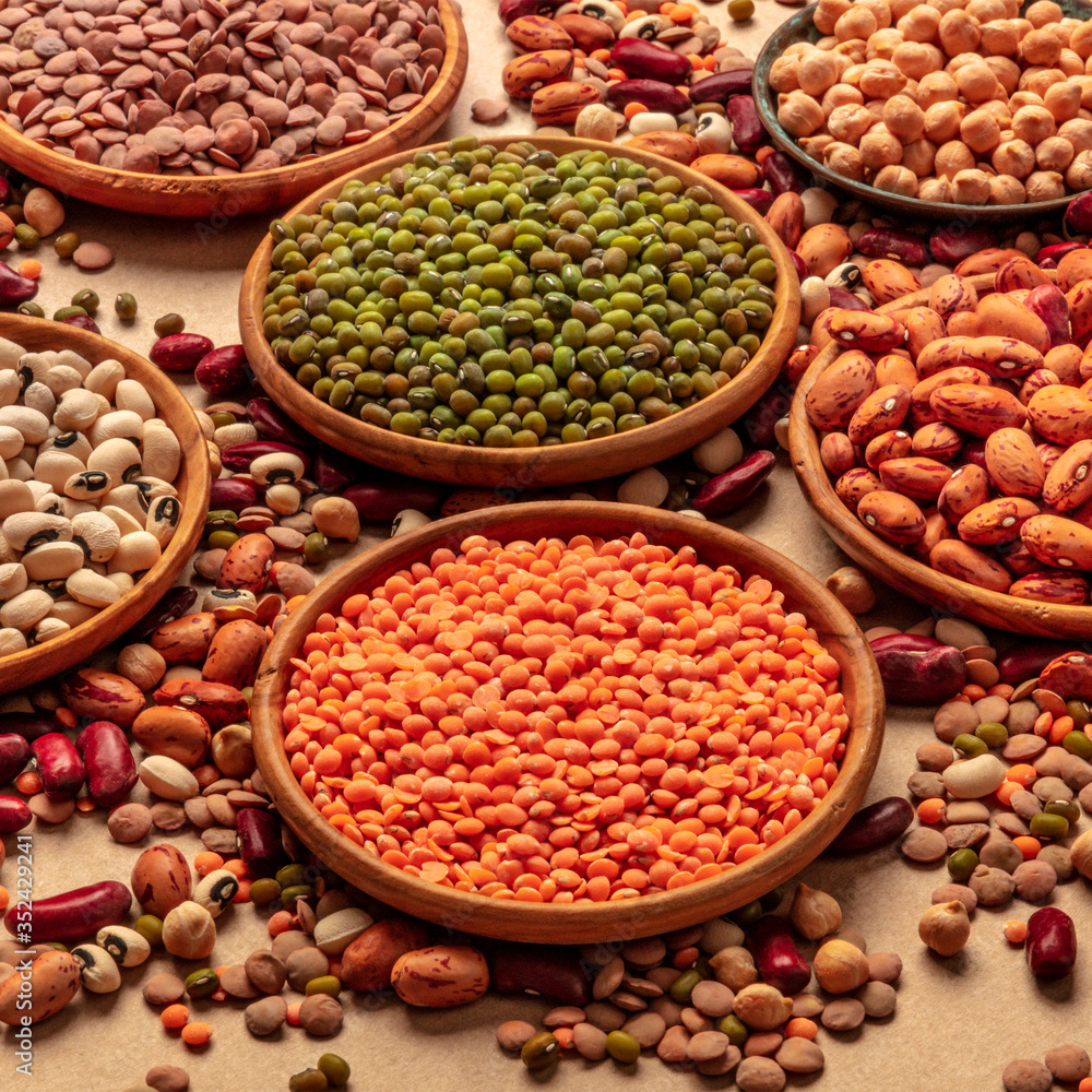 Fototapeta premium Legumes assortment on a brown background. Lentils, soybeans, chickpeas, red kidney beans, a vatiety of pulses, square shot