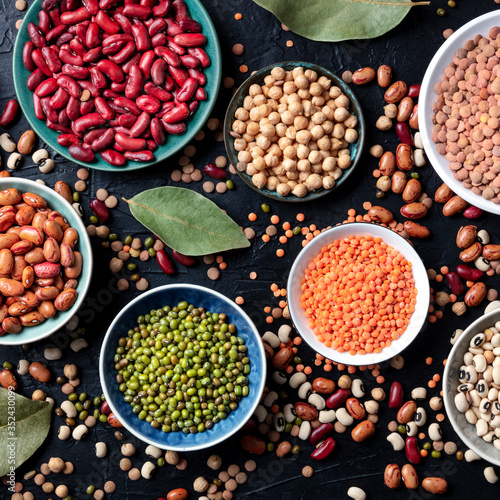 Legumes assortment, overhead square shot on a dark background. Lentils, soybeans, chickpeas, red kidney beans, a vatiety of pulses