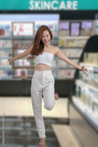 Portrait of beautiful asian woman choosing personal care product in cosmetic department. Happy woman shopping skincare.
